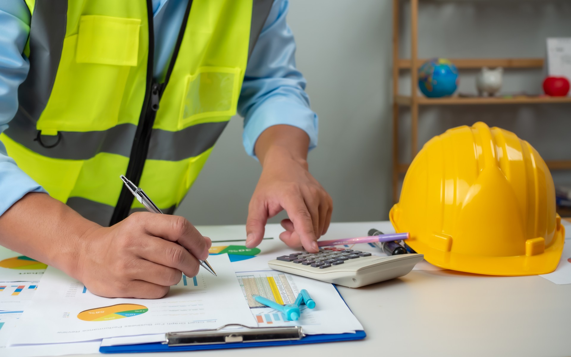 A foreman sits at a desk in an office, Calculating costs, Planning construction, Calculating structures, Planning and calculating project construction costs, Project presentation plan.